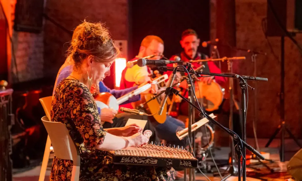 un petit orchestre de de musique iranienne joue sur des instruments de musique et chante.