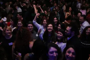 Beaucoup de monde est debout dans un salle et danse sur de la musique iranienne